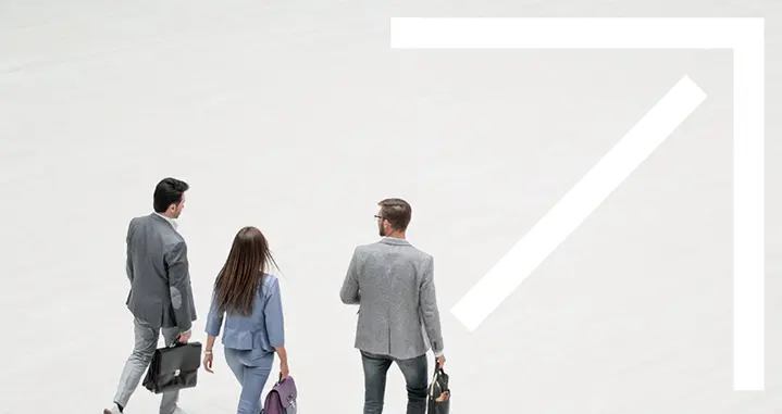 Three employees walking through an atrium