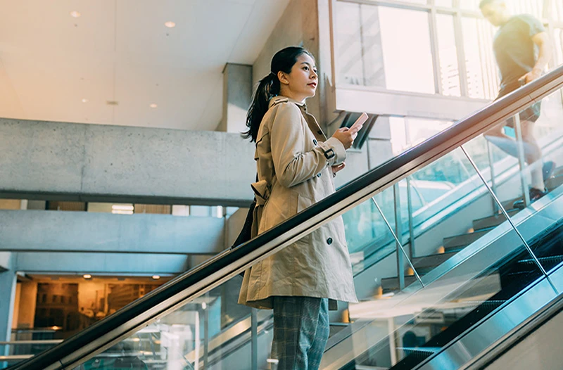 Woman travelling up an escalator