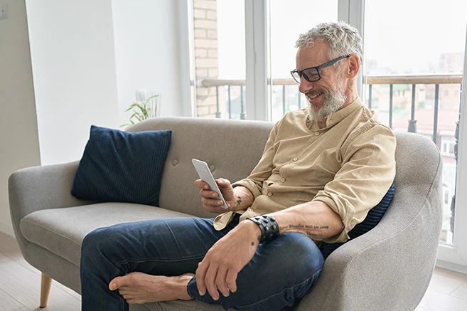 Man sat on couch on mobile
