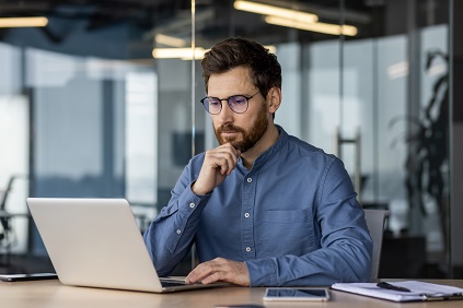 Man sat at desk reading annual DC chair's statement.
