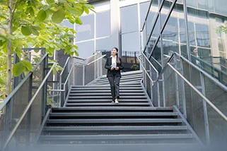 Business woman walking down the stairs outside office