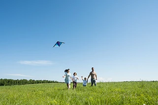 Family flying kite in field