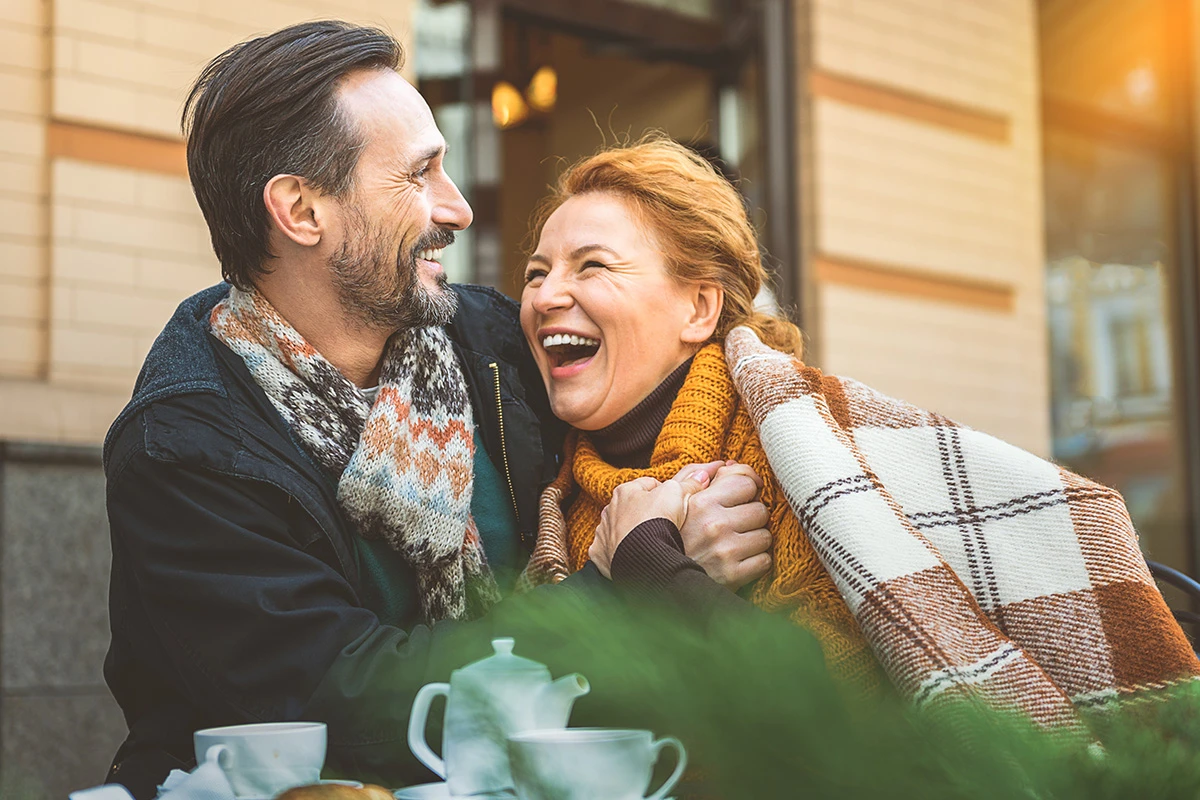 Couple Sat Outside Laughing at a Cafe
