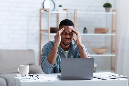 Young Man Thinking While Using Laptop