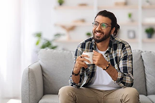 Man sat on sofa with a coffee