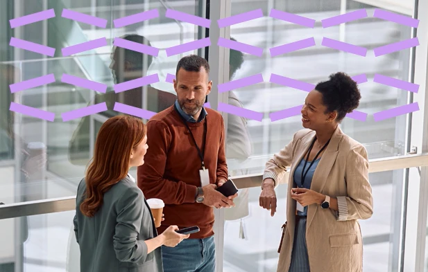 Three employees talking in an atrium