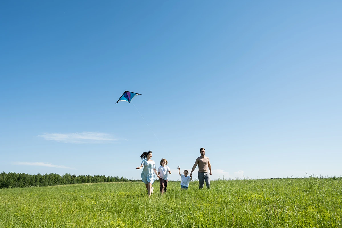 Family playing with a kite in a field