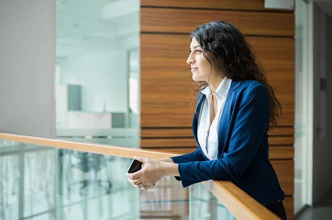 Business woman leaning over balcony in atrium