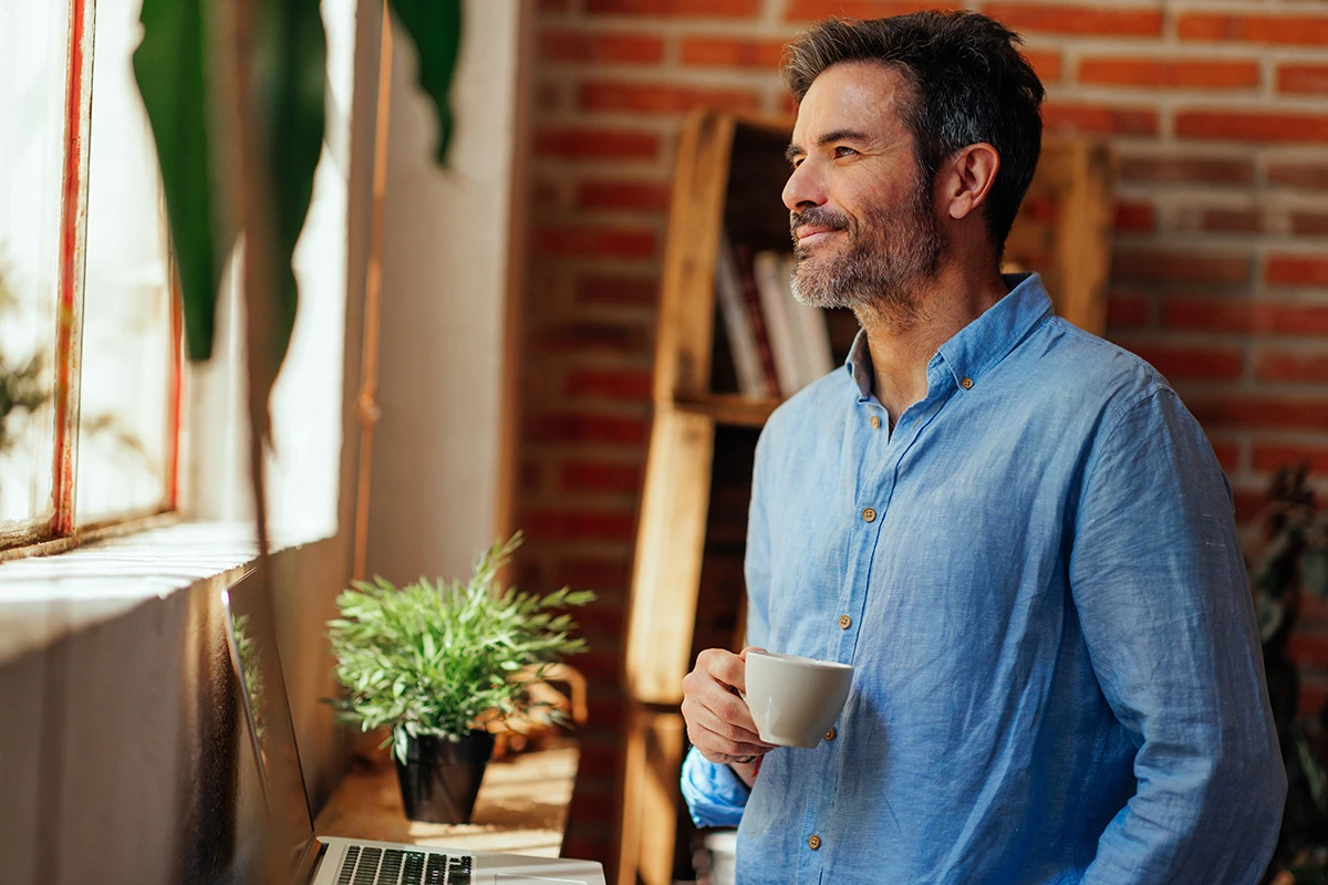 Man smiling looking out of a window
