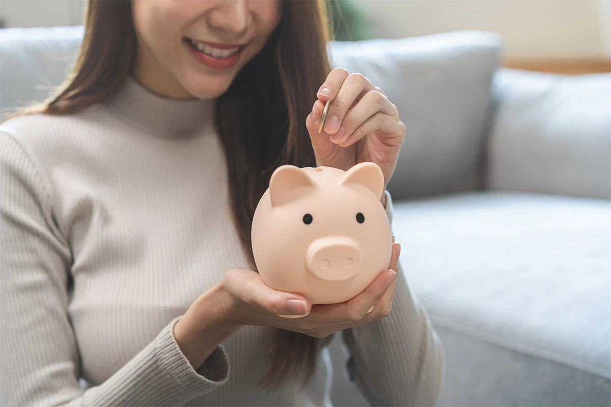 Woman putting money into a piggybank