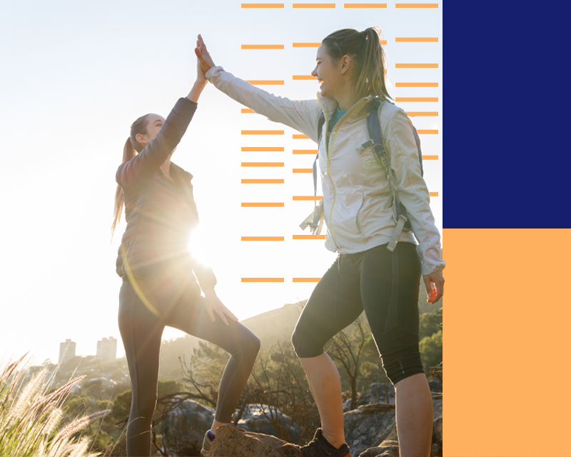 Two women doing a high five on a run