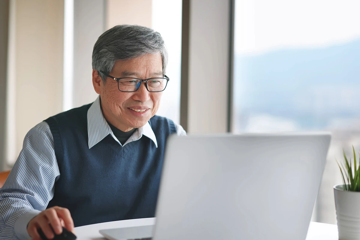 Man sat at a desk on a laptop