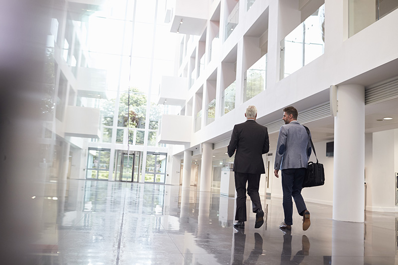 Two colleagues walking through an atrium