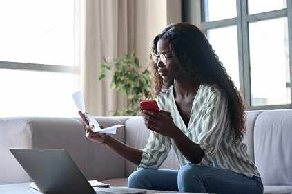 Young Woman Checking Documents On Laptop And Phone