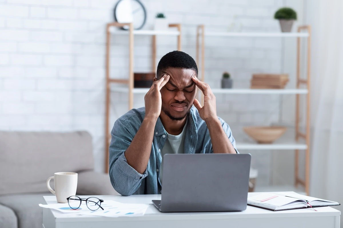 Young Man Thinking While Using Laptop