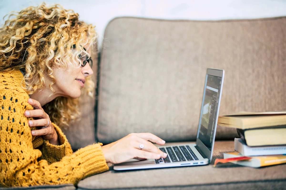 Woman Using Laptop On Sofa