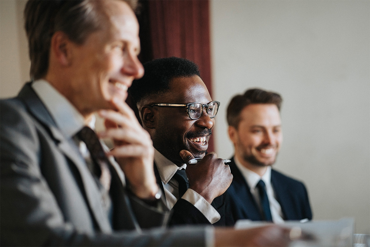 Three employers smiling in the boardroom
